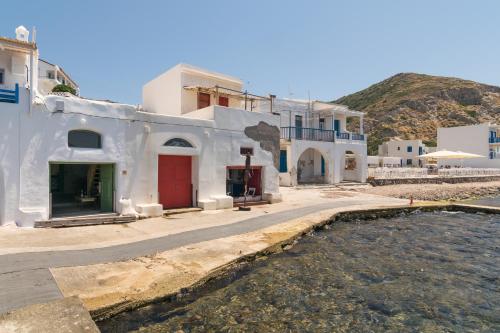 a group of white buildings and a body of water at Aganta Klima Syrma in Klima