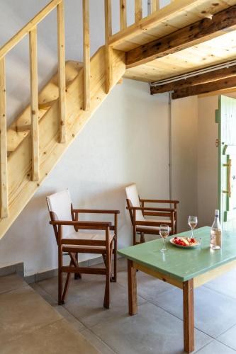 a dining room with a table and chairs and stairs at Aganta Klima Syrma in Klima