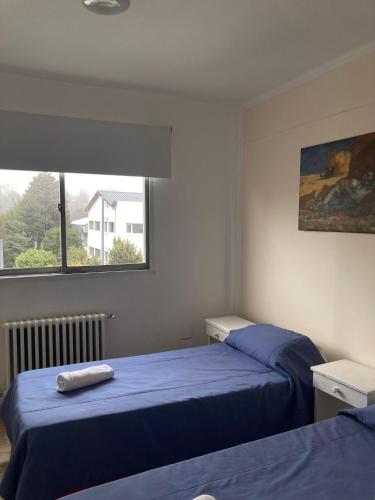 a bedroom with two beds and a window at Hotel Costa del Lago in San Carlos de Bariloche