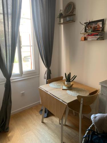 une table à manger avec deux chaises et une fenêtre dans l'établissement Bel appartement à côté du Vélodrome et des plages, à Marseille