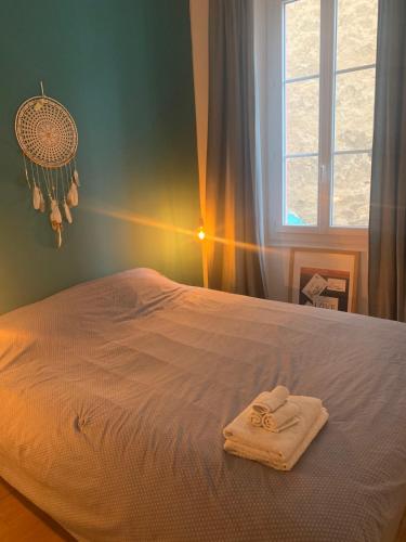 - un lit avec une serviette dans une chambre dans l'établissement Bel appartement à côté du Vélodrome et des plages, à Marseille