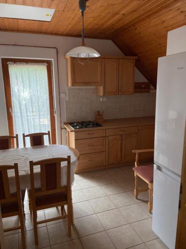 una cucina con un tavolo e alcune sedie e un tavolo e una cucina di 14 férőhelyes ház saját stéggel, játszótérrel Balatonfenyvesen vízparti utcában a Balatonfenyves