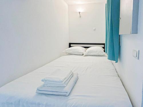 un lit avec des draps blancs et des serviettes dessus dans l'établissement Élégance Azuréenne - piscine et parking, à Villefranche-sur-Mer