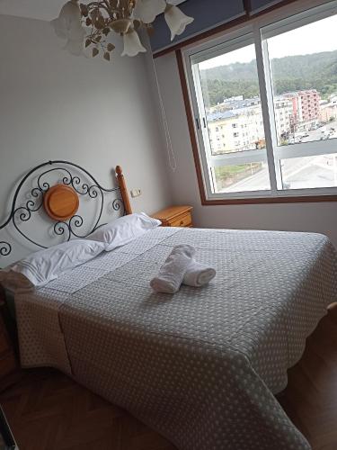 a bedroom with a bed with two towels on it at Apartamento Playa de Covas in Viveiro