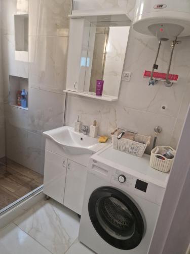 a white bathroom with a washing machine and a sink at Relax In in Belgrade