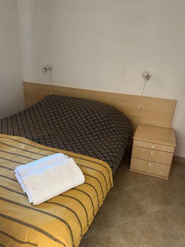 - une chambre avec un lit et une serviette blanche dans l'établissement Les jardins de la mer marine de Bravone, à Linguizzetta