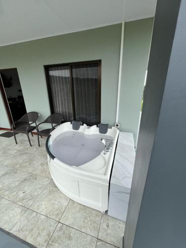 a white bath tub in a room with a table at Paradise Experience Costa Rica in Pueblo Nuevo