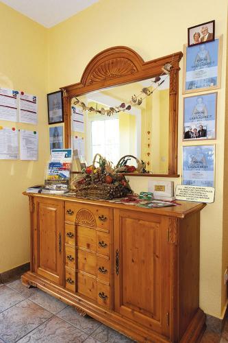 a large wooden dresser with a mirror on top of it at Pension Villa Irene in Kurort Gohrisch