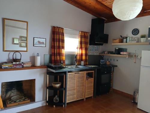 a kitchen with a counter and a fireplace at sunset in Raches