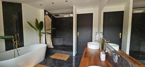 une salle de bain avec deux lavabos et une baignoire et deux toilettes dans l'établissement Villa Pessac jardin luxuriant et piscine chauffée, à Pessac