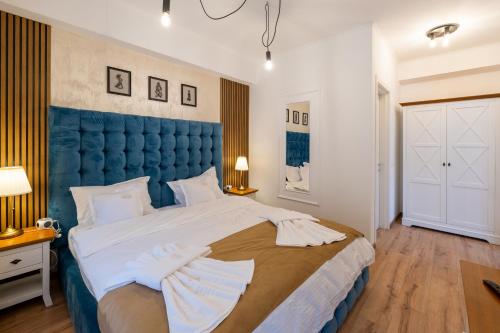 a bedroom with a large bed with a blue headboard at Domeniul Terraqua in Miceşti