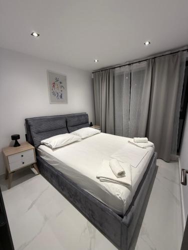 a bedroom with a large bed with white sheets at kallithea maisonette in Kallithea Halkidikis