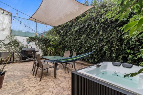 a patio with a hammock and a table and a tub at Casa Encanto - 3Bdr, 2.5bath w/Jacuzzi and Parking in Puerto Vallarta