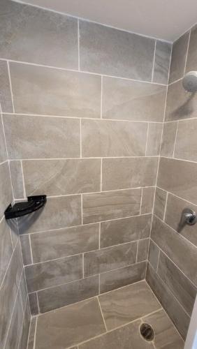 a bathroom with a shower with a tiled wall at Paktinemi Diamante Fantastic View Beach Club in Acapulco