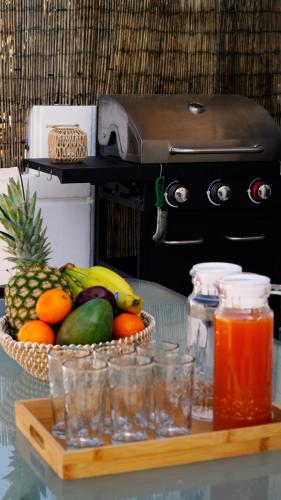 a basket of fruit on a table with a drink at IKARUS apartment with courtyard & pool in Chania in Stérnai