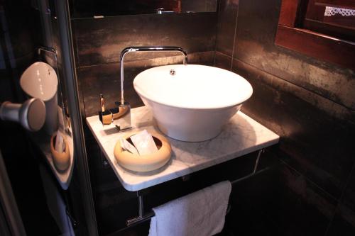 ein Badezimmer mit einem weißen Waschbecken auf der Theke in der Unterkunft El Molín de Petra in Valbucar