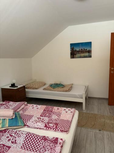 a room with two beds and a painting on the wall at Apartman Salus in Tuzla