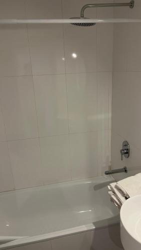 a white bathroom with a tub and a sink at Torres Brickell Six in Tigre