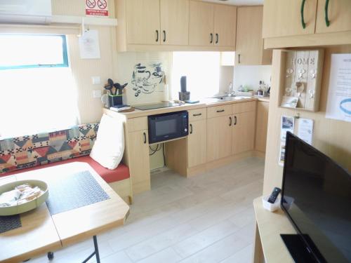 a kitchen with a couch and a table in a room at Le Cèdre in Montlay-en-Auxois