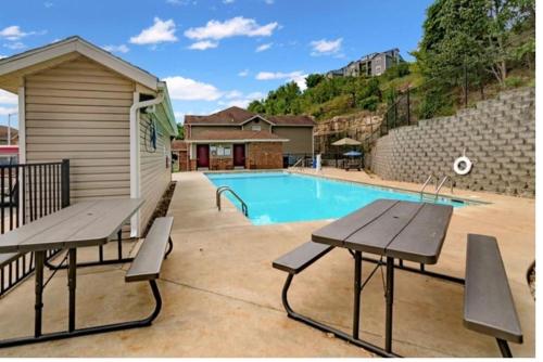 a swimming pool with two picnic tables next to a building at Ferris view horizon in Branson