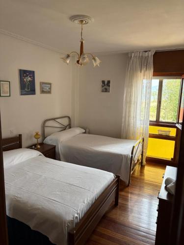 a hotel room with two beds and a window at Aires de Playa in Arija