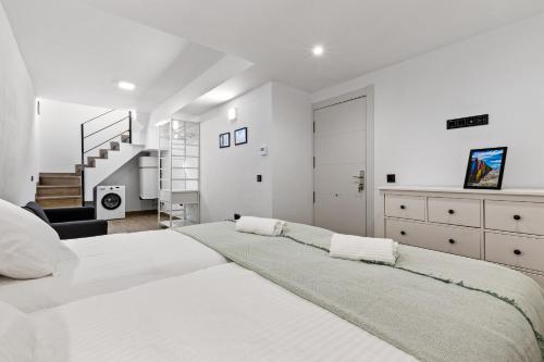 a white bedroom with a large bed and a staircase at Urban Oasis in Fuengirola
