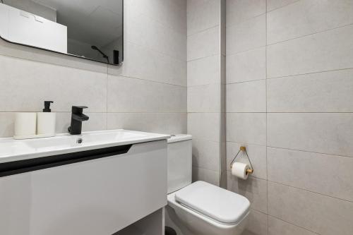 a bathroom with a toilet and a sink and a mirror at Urban Oasis in Fuengirola