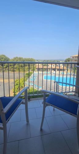 un banc bleu sur un balcon avec une piscine dans l'établissement La Dolce Vita, à Balaruc-les-Bains