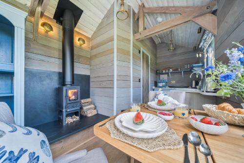 a kitchen with a table and a wood stove at The Cabin at Salcombe Farm in Salcombe