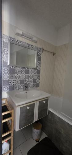 une salle de bain avec un lavabo, un miroir et une baignoire dans l'établissement La Dolce Vita, à Balaruc-les-Bains