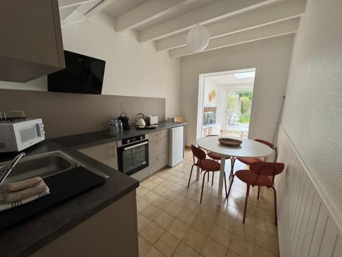 une cuisine avec une table et des chaises dans une cuisine dans l'établissement Logement proche Aéroport Nantes, à Saint-Aignan-Grand-Lieu