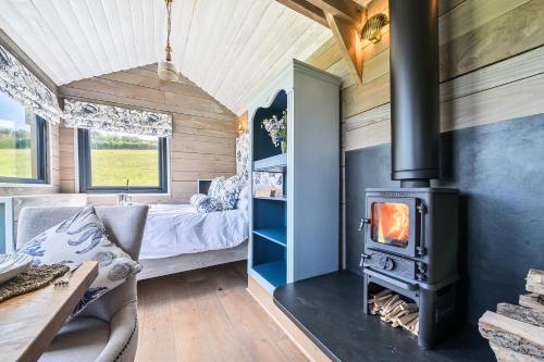 a living room with a wood stove in a tiny house at The Cabin at Salcombe Farm in Salcombe