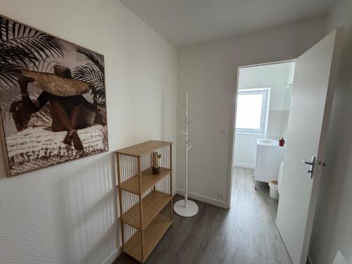 Baño blanco con una pintura en la pared en Logement proche Aéroport Nantes, en Saint-Aignan-Grand-Lieu