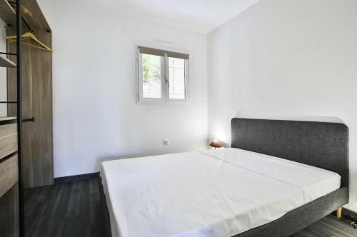 une chambre avec un grand lit avec une fenêtre dans l'établissement Superbe 2 pièce tout confort - AC, piscine, Park, à Villefranche-sur-Mer