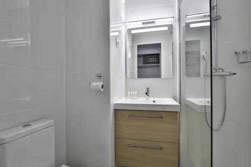 une salle de bain blanche avec un lavabo et une douche dans l'établissement Superbe 2 pièce tout confort - AC, piscine, Park, à Villefranche-sur-Mer