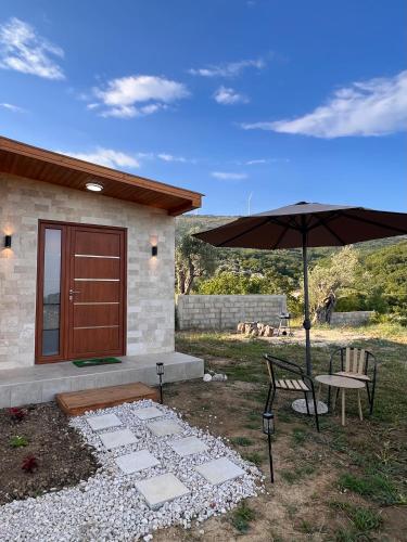 a patio with a table and an umbrella and a bench at Casa Arte in Ulcinj