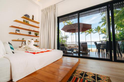 a bedroom with a bed and a view of the ocean at Nacpan Beach Villas Managed by H Hospitality Group in El Nido