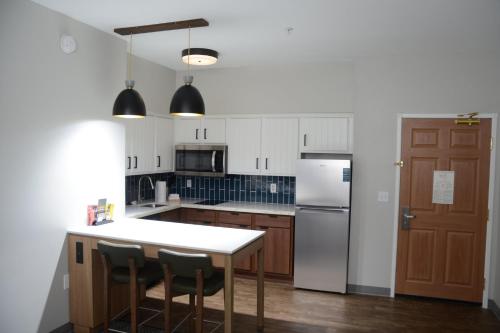 a kitchen with a table and a refrigerator at Staybridge Suites Tucson Airport by IHG in Tucson