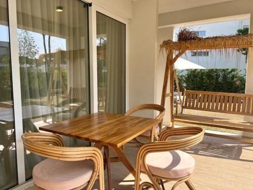 une table et des chaises en bois sur un porche dans l'établissement San Pietro Resort -Luxury garden apartment Gjiri I Lalezit, à Lalzit Bay