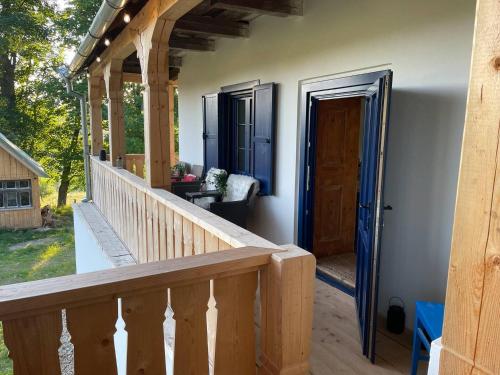 a porch of a house with a wooden door at Casa cu copaci Romanian historical farmhouse in Mărişel