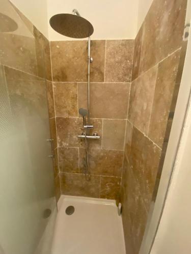 une douche avec pommeau de douche dans une salle de bain dans l'établissement Centre Roquemaure, à Roquemaure