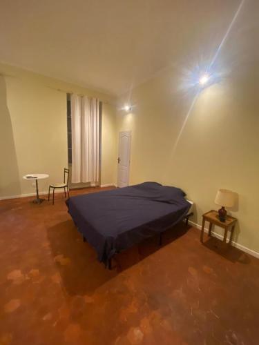 une chambre avec un lit, une table et une lampe dans l'établissement Centre Roquemaure, à Roquemaure