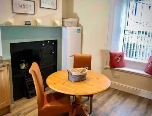 a kitchen with a table and a fireplace and a table and chairs at The MireHouse - Georgian rural retreat in Ullock