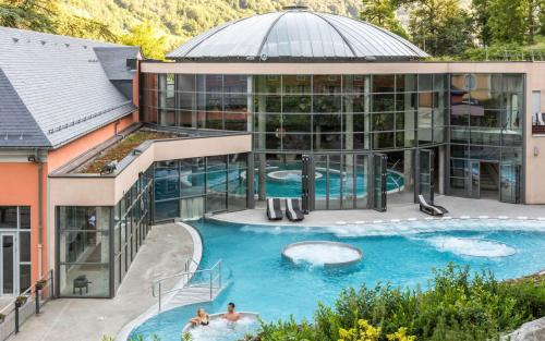 - une vue aérienne sur un grand bâtiment avec une piscine dans l'établissement Cauterets, à Cauterets