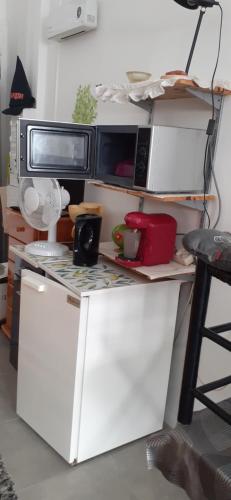 une cuisine avec un four micro-ondes au-dessus d'un comptoir dans l'établissement Chambre 21m2, à Sigean