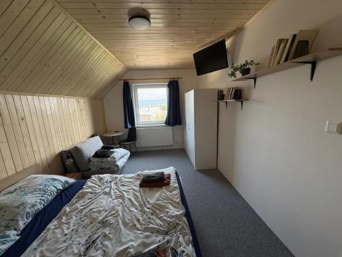 a small room with a bed and a refrigerator at Chata na lúke in Tatranska Strba