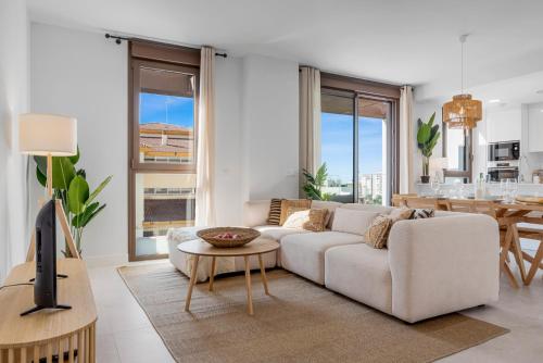 een woonkamer met een witte bank en een tv bij Casa Del Toro Estepona in Estepona