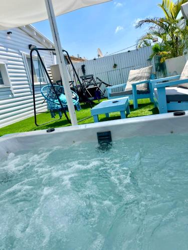 a swimming pool with a table and chairs in a yard at Cancun in Netanya