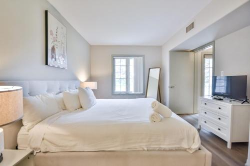 une chambre blanche avec un grand lit et une télévision dans l'établissement Highland Hideaway 1BR King Suite, à Shanty Bay