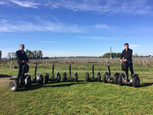two men are riding onicycles in a field at Château la Renommée in Saint-Laurent-des-Combes